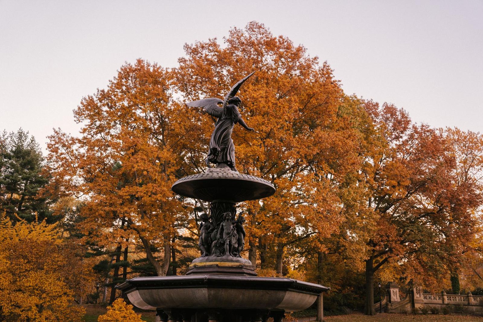 Fountain with Statues Placed in Park in Autumn Time